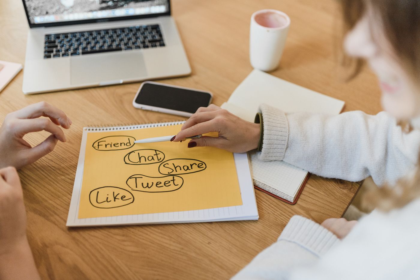 Handwritten content brainstorm on a notepad next to a laptop, mapping topics before a content audit begins