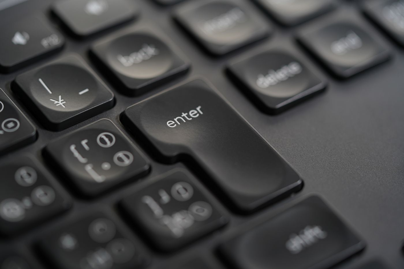 Close-up of a black keyboard enter key, ready to hit publish