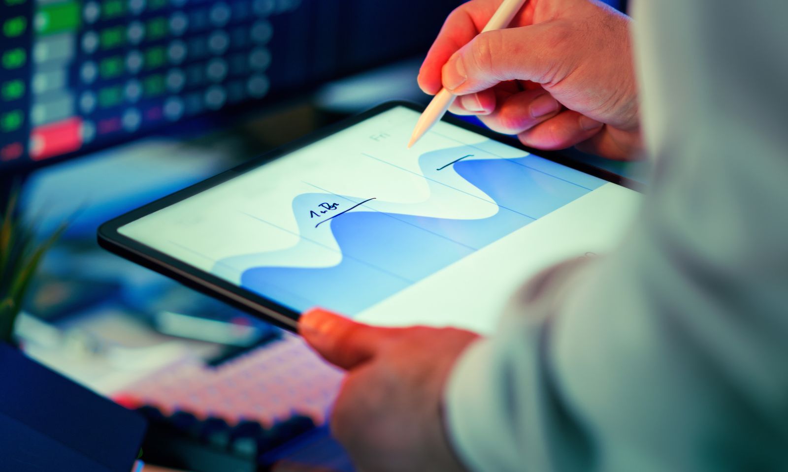 Close-up of a hand using a stylus to review a performance chart on a tablet
