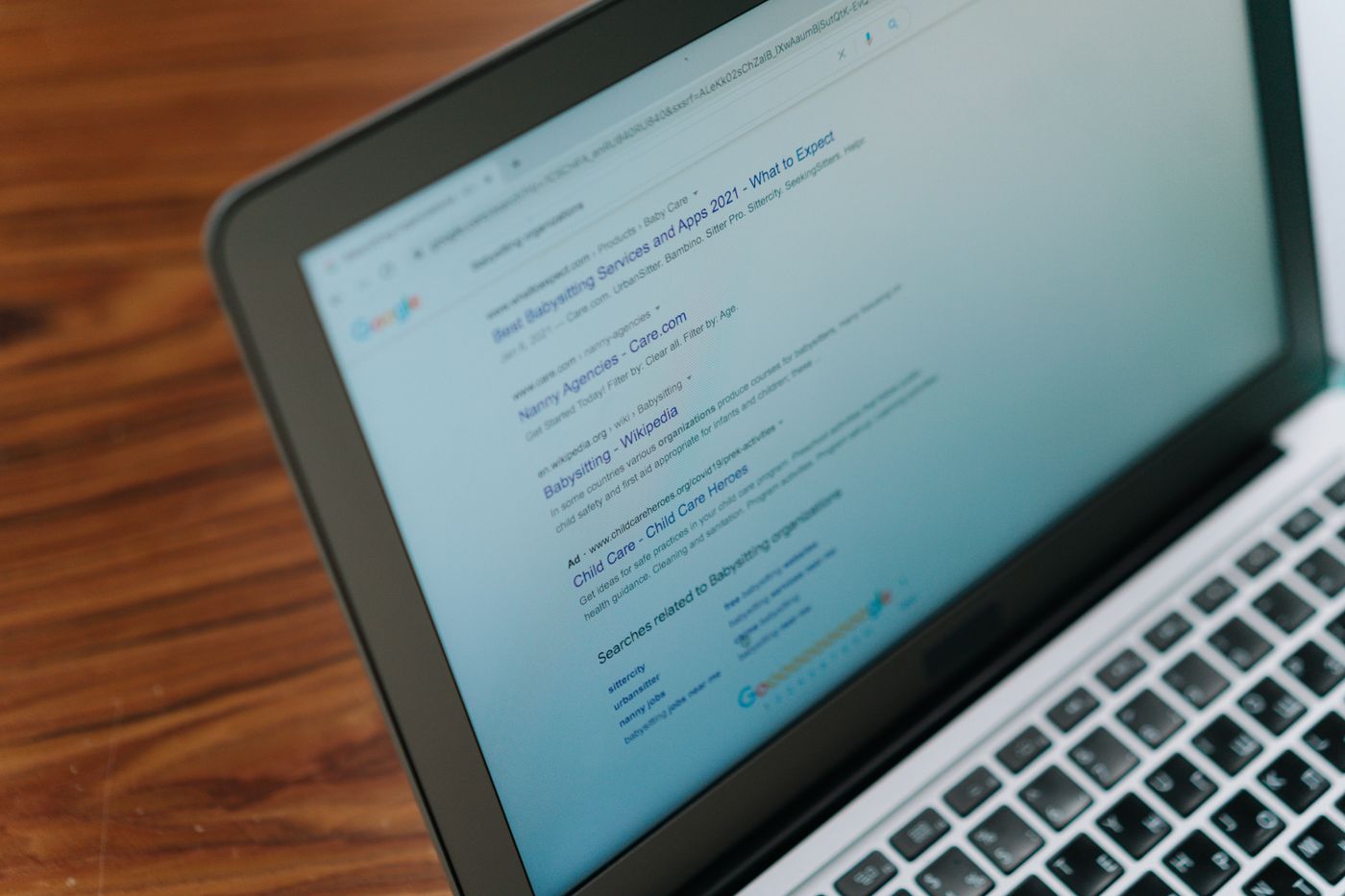 Laptop screen showing a Google search results page with a paid ad listing