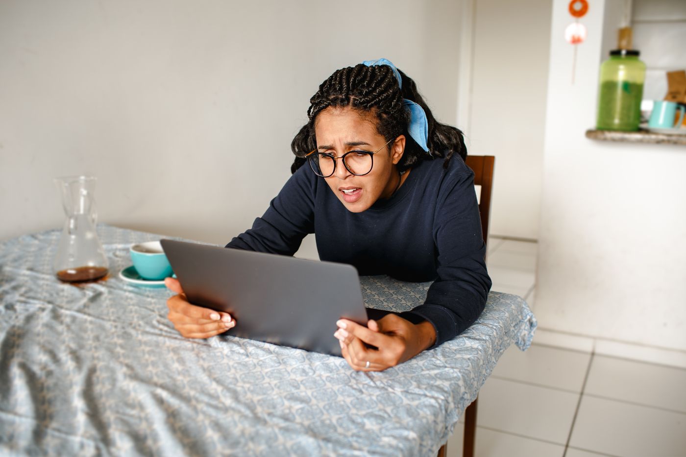 Woman frowning in frustration while looking closely at her laptop screen