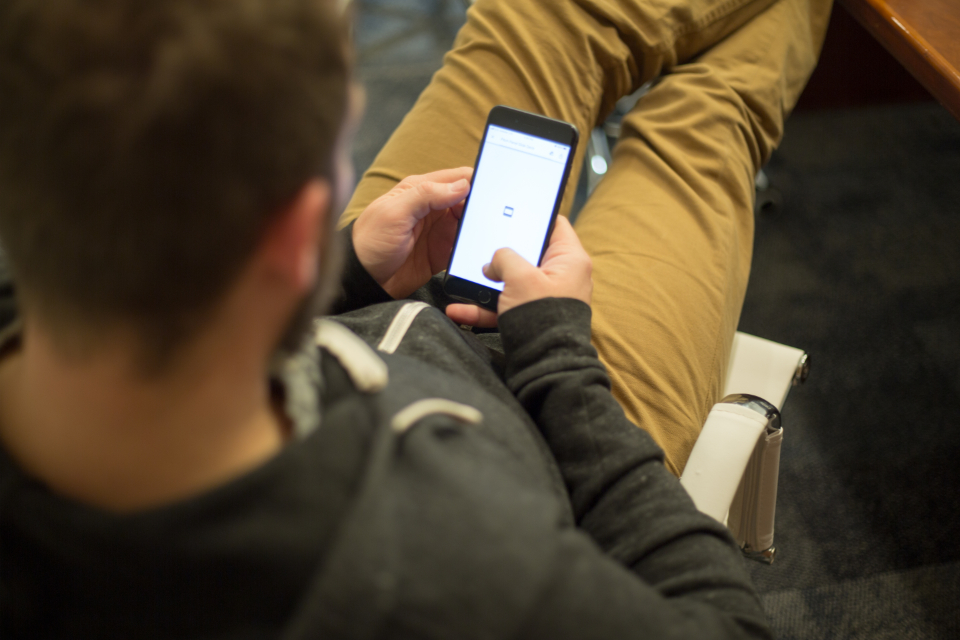 Person scrolling a smartphone feed, the kind of native, platform-specific consumption repurposed content has to be reshaped for