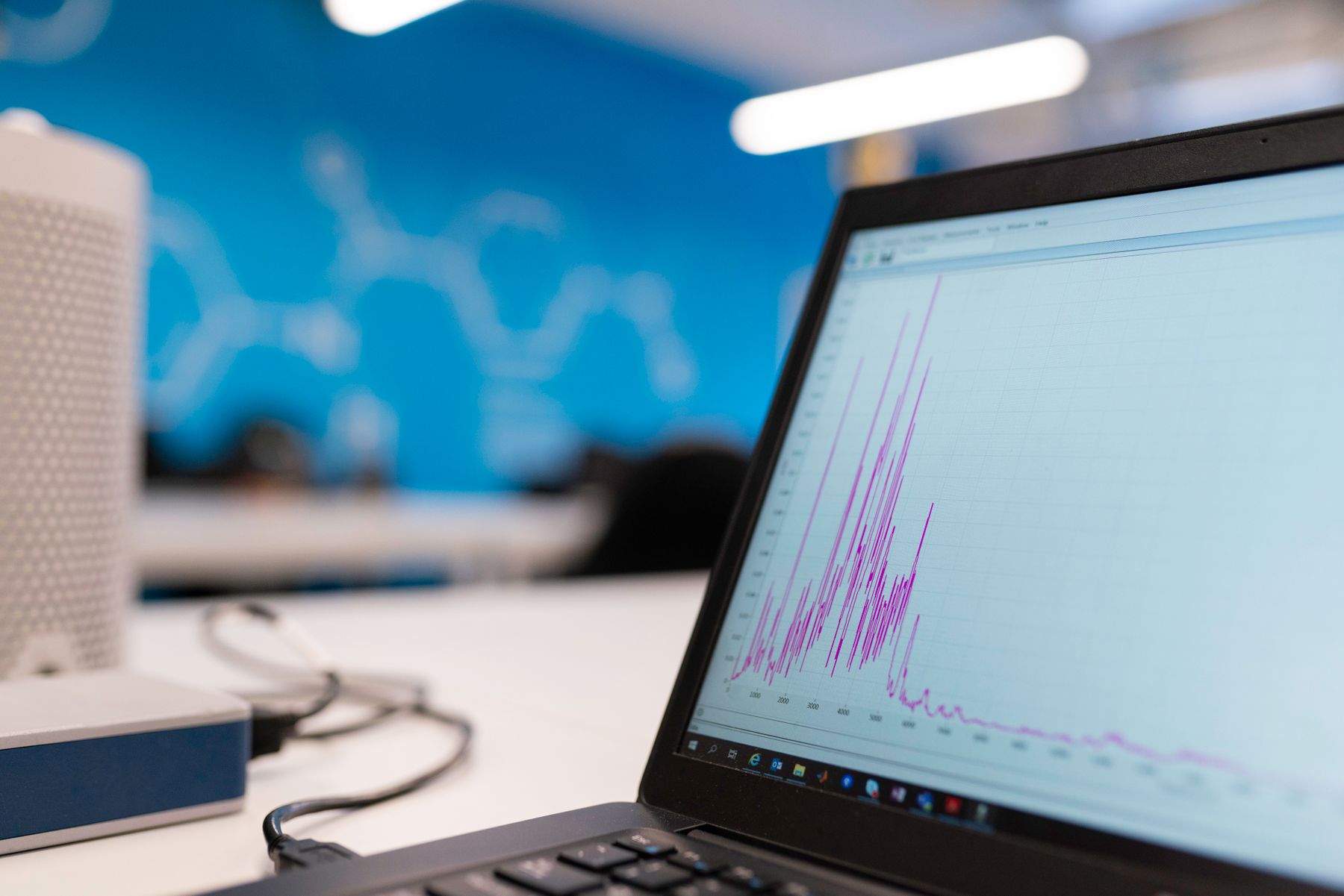 Laptop screen displaying a colorful upward-trending data graph on a desk